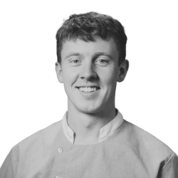 Black and white headshot of a smiling young man.
