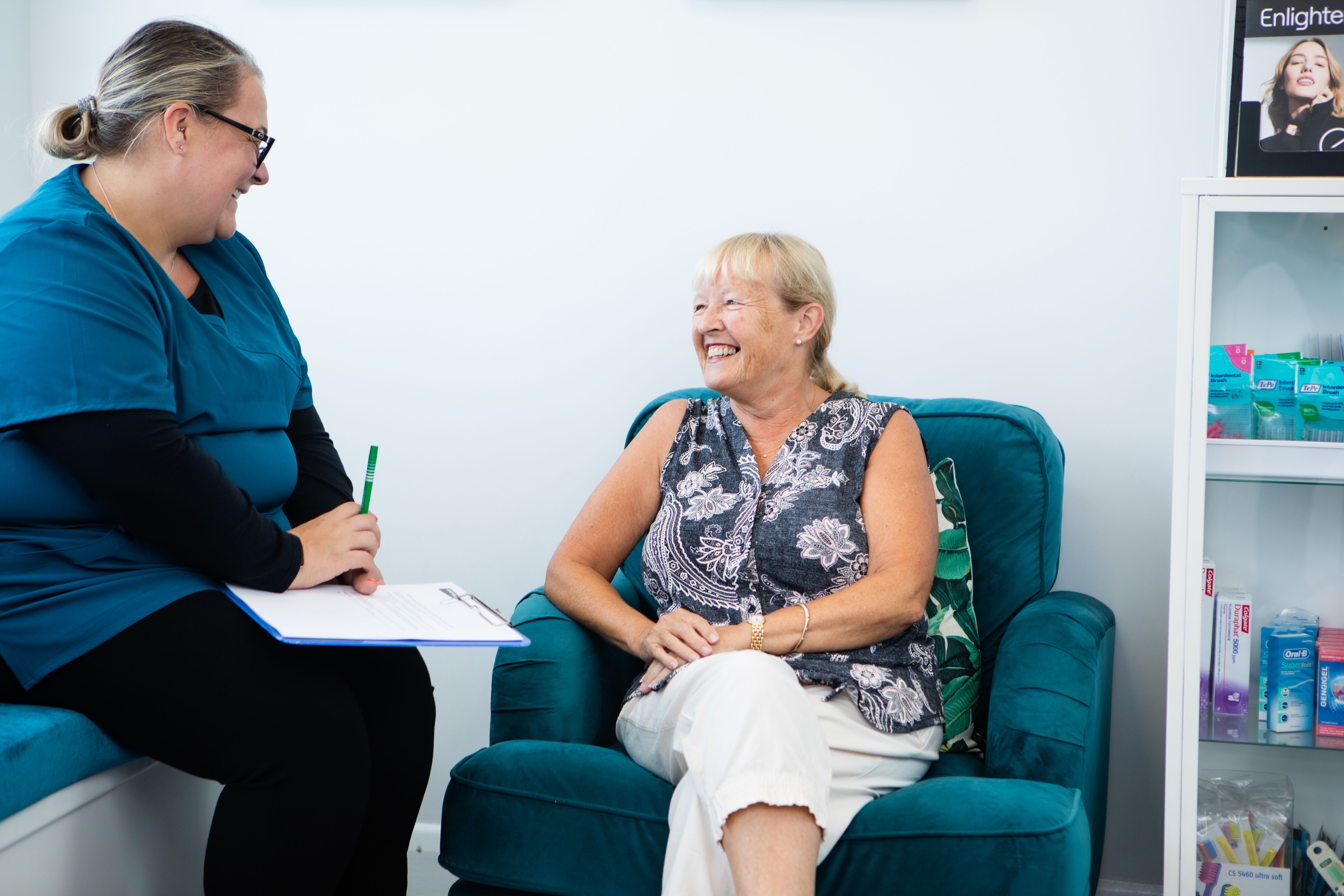 Smiling dental professional consults with a happy patient.