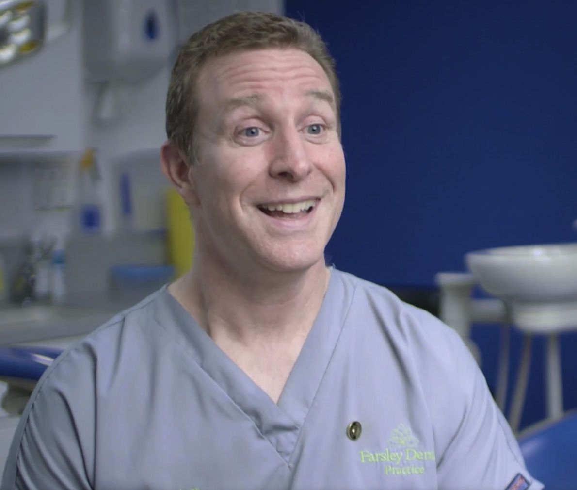 a dentist is smiling while sitting in a dental chair in a dental office .