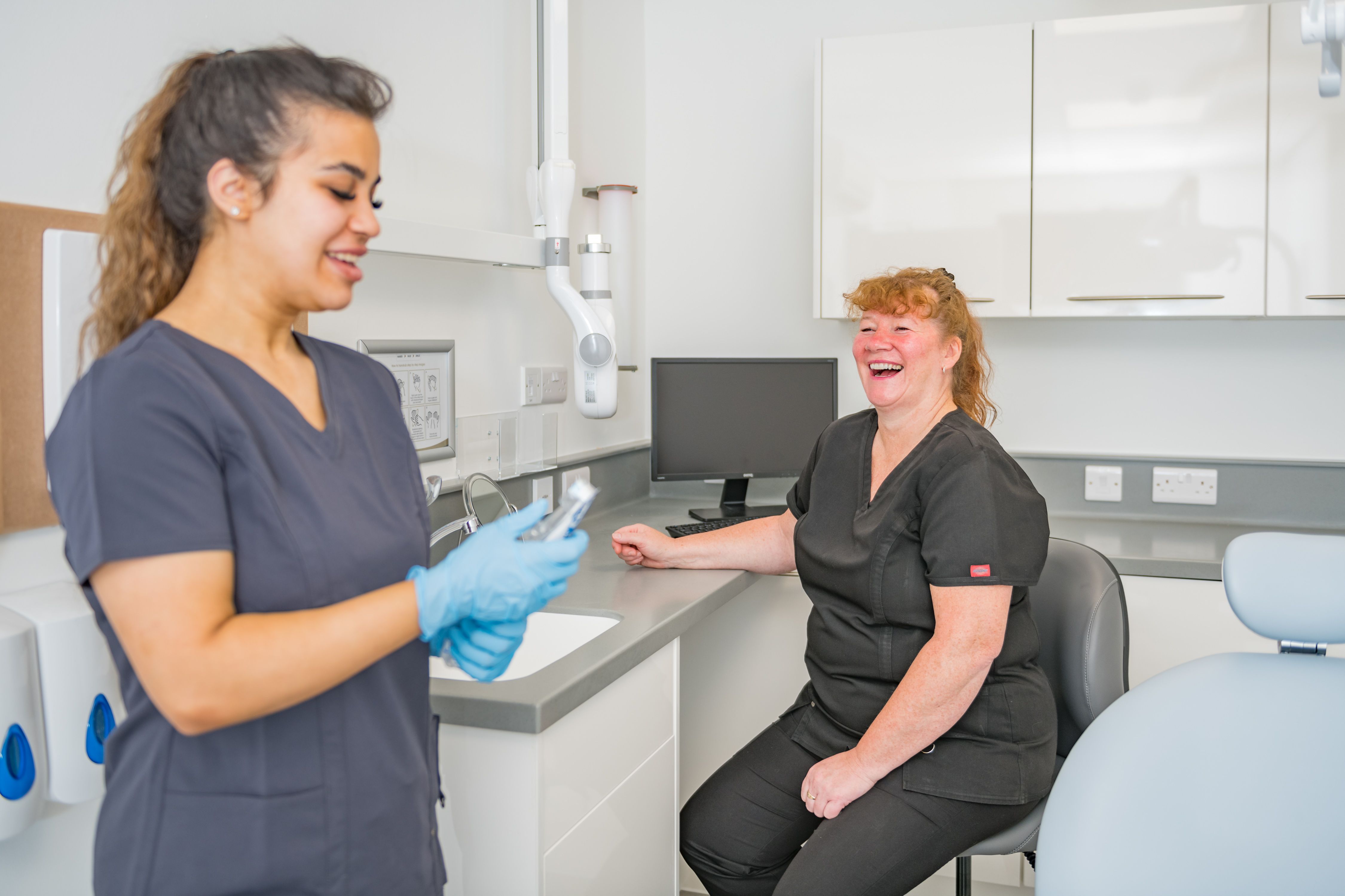 a female dentist is talking to a patient in a dental office .