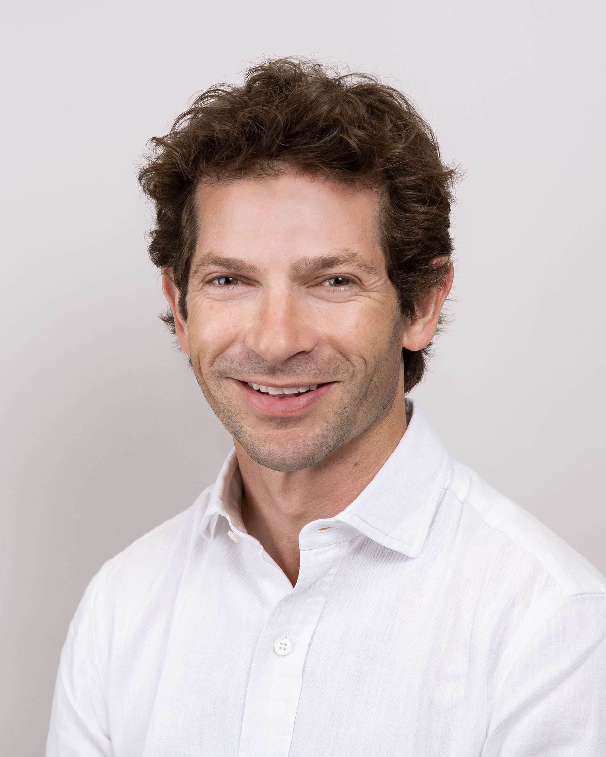 Sam Waley-Cohen in a white shirt is smiling for the camera .